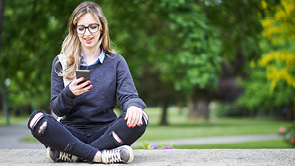 jonge vrouw zit buiten met gekruiste benen