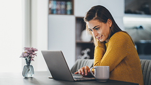 jongedame in gele trui met laptop