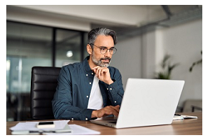 Een man zit achter een laptop