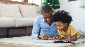 opa en kleinkind liggen te lezen op tapijt