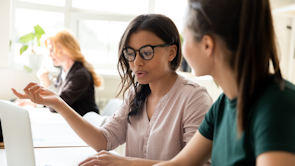 twee dames achter laptop praten